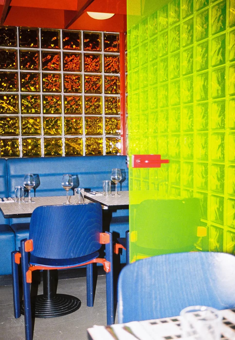 A blue booth by the glass-brick wall